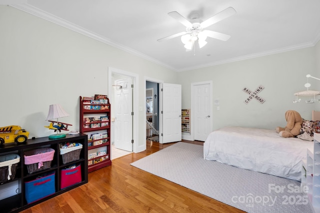 bedroom with ornamental molding, a ceiling fan, and wood finished floors