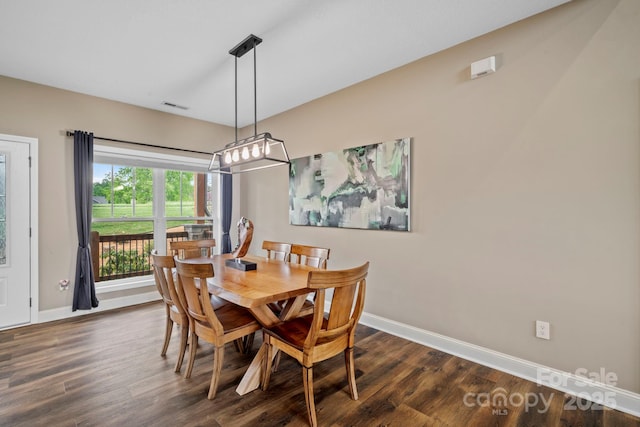 dining space featuring an inviting chandelier, baseboards, dark wood finished floors, and visible vents