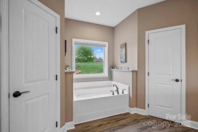 full bathroom with baseboards, a bath, wood finished floors, and recessed lighting