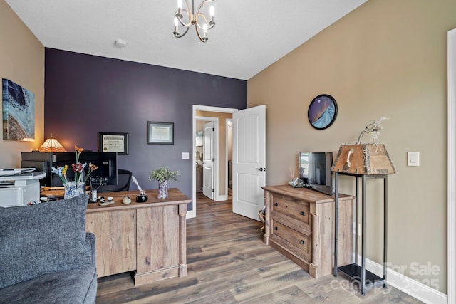 office area featuring baseboards, a notable chandelier, and wood finished floors