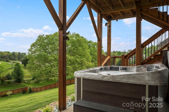 deck with stairs, a hot tub, fence, and a yard