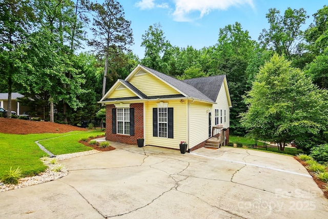 2745 Stockwood Dr, Gastonia, NC 28056 - view of front of home featuring a front yard, concrete driveway, roof with shingles, a patio area, and brick siding