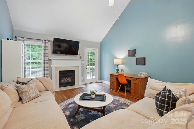 2745 Stockwood Dr, Gastonia, NC 28056 - living room featuring wood finished floors, a fireplace with flush hearth, a ceiling fan, baseboards, and high vaulted ceiling