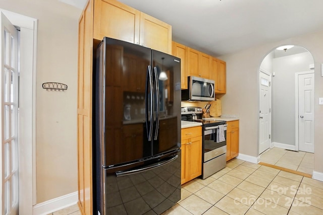 2745 Stockwood Dr, Gastonia, NC 28056 - kitchen with stainless steel appliances, arched walkways, light brown cabinets, light countertops, and light tile patterned floors