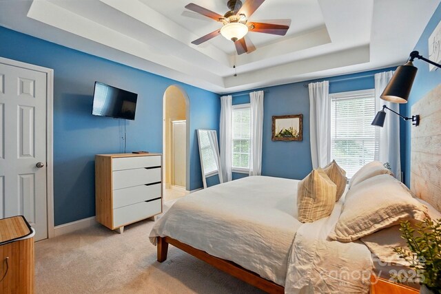 2745 Stockwood Dr, Gastonia, NC 28056 - bedroom with light colored carpet, a tray ceiling, baseboards, a ceiling fan, and arched walkways