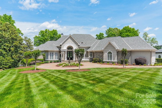 140 Lightship Dr, Mooresville, NC 28117 - view of front facade featuring stone siding, a front yard, a chimney, and a shingled roof