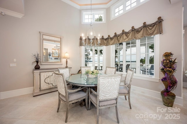 140 Lightship Dr, Mooresville, NC 28117 - dining space with a chandelier, light tile patterned floors, crown molding, baseboards, and a high ceiling