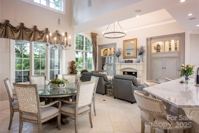 140 Lightship Dr, Mooresville, NC 28117 - dining area featuring a chandelier, light tile patterned floors, a fireplace, recessed lighting, and ornamental molding
