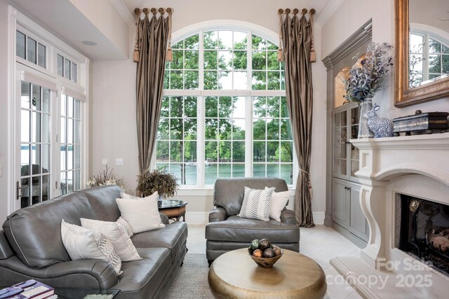 140 Lightship Dr, Mooresville, NC 28117 - sitting room featuring healthy amount of natural light, light tile patterned floors, a fireplace with raised hearth, and crown molding