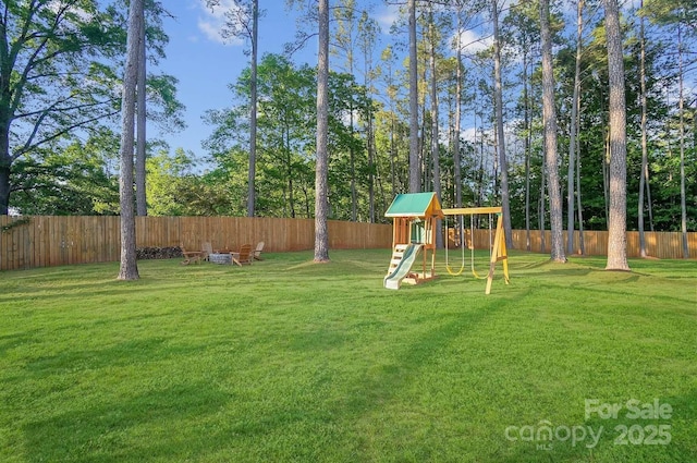 view of yard featuring a fenced backyard and a playground