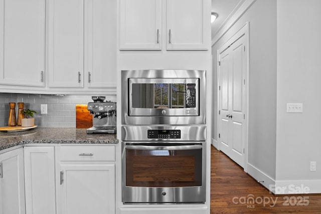 10822 Brandie Meadow Ln, Huntersville, NC 28078 - kitchen featuring stainless steel microwave, dark stone counters, tasteful backsplash, and white cabinetry