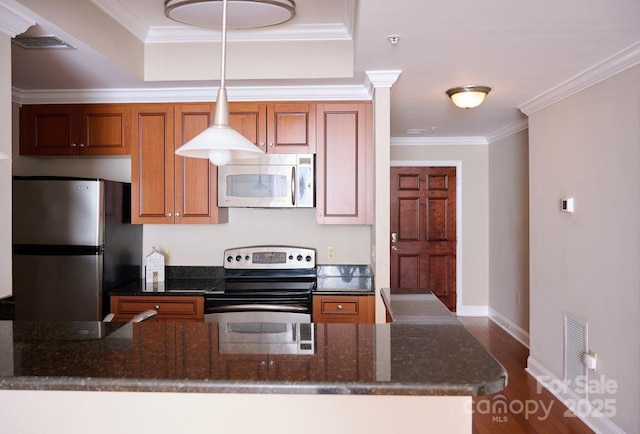 kitchen with brown cabinets, dark wood-style flooring, appliances with stainless steel finishes, visible vents, and ornamental molding