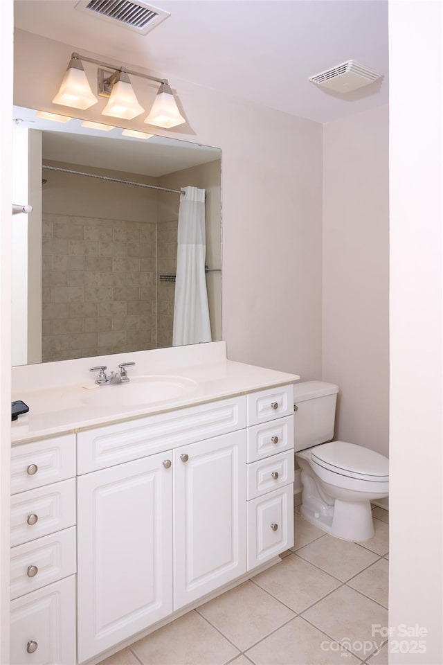 bathroom with toilet, tile patterned floors, visible vents, and vanity