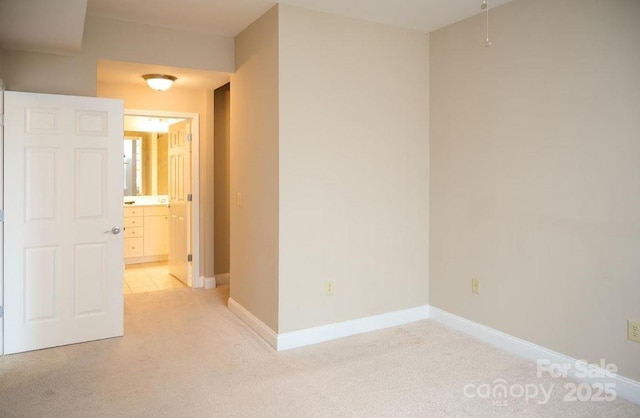 unfurnished room with baseboards and light carpet