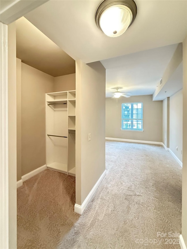 walk in closet with carpet floors, a ceiling fan, and visible vents