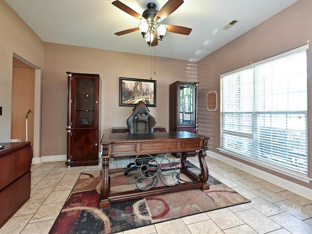 office space with baseboards, ceiling fan, and visible vents