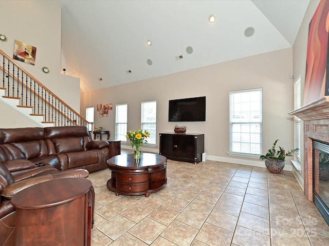 living room with visible vents, a brick fireplace, stairway, high vaulted ceiling, and light tile patterned flooring