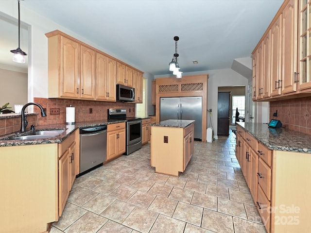 kitchen with appliances with stainless steel finishes, tasteful backsplash, a center island, a sink, and dark stone counters