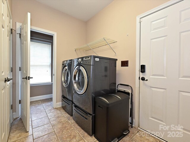 laundry room featuring laundry area, baseboards, light tile patterned floors, and washer and dryer