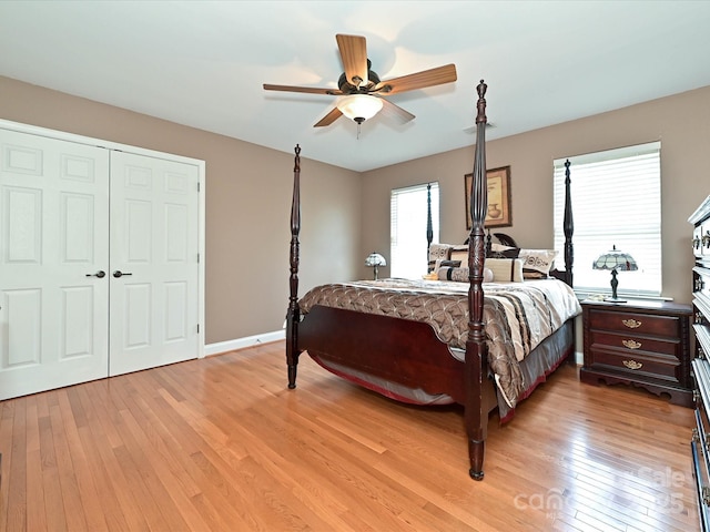 bedroom featuring a closet, light wood finished floors, ceiling fan, and baseboards