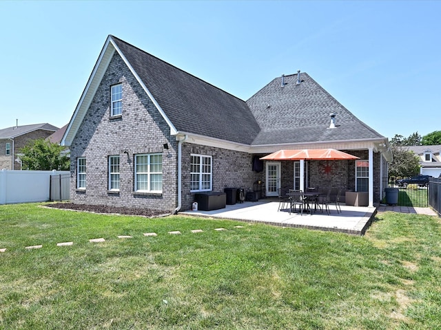rear view of house with brick siding, a fenced backyard, a patio area, and a lawn