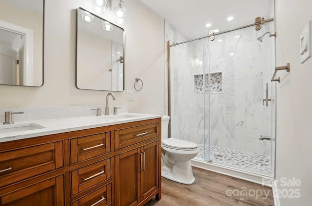 bathroom with double vanity, a sink, toilet, and a shower stall