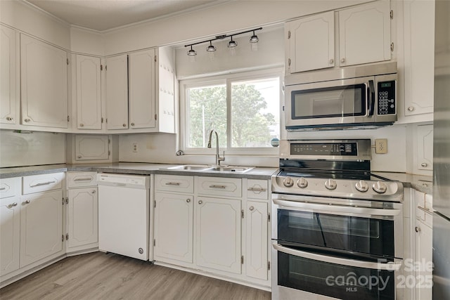 kitchen featuring crown molding, white cabinets, a sink, light wood-style flooring, and stainless steel appliances