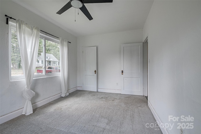 unfurnished bedroom with baseboards, carpet, and a ceiling fan
