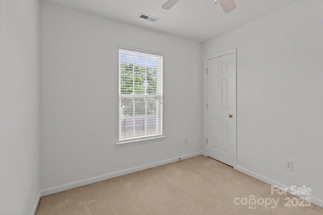 empty room featuring light carpet, baseboards, and a ceiling fan