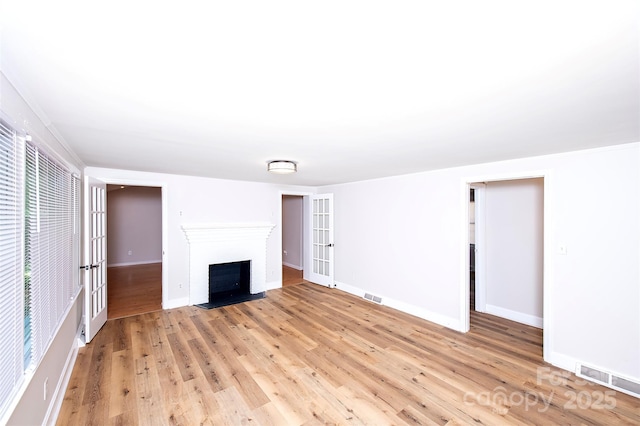 3933 Planters Pl, Indian Trail, NC 28079 - unfurnished living room featuring light wood-type flooring and a fireplace with flush hearth