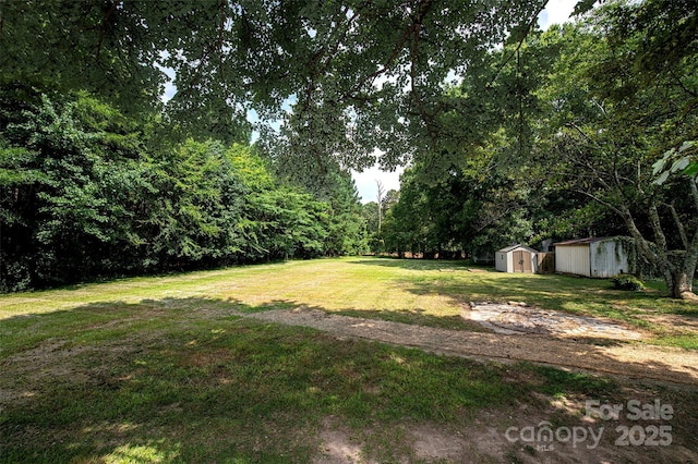 3933 Planters Pl, Indian Trail, NC 28079 - view of green lawn featuring a storage unit and a wooded view
