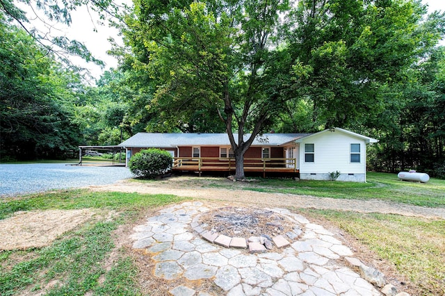 3933 Planters Pl, Indian Trail, NC 28079 - view of front facade featuring crawl space, a wooden deck, a front lawn, gravel driveway, and a carport