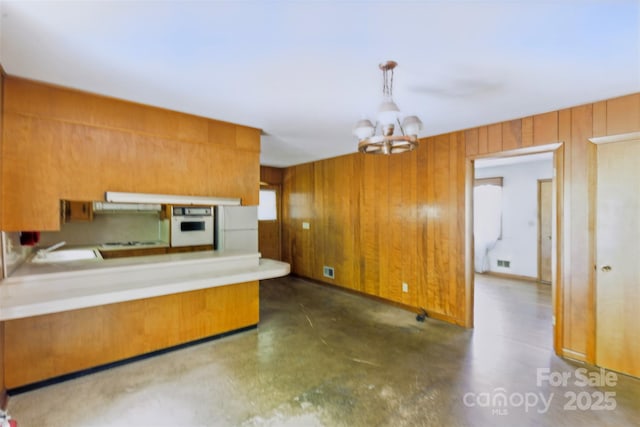 3120 Mineral Springs Mountain Rd, Valdese, NC 28690 - kitchen with white appliances, wood walls, brown cabinetry, a chandelier, and a sink