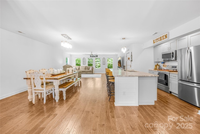 5615 American Way, Denver, NC 28037 - kitchen featuring a sink, light wood-style floors, a kitchen island with sink, stainless steel appliances, and open floor plan