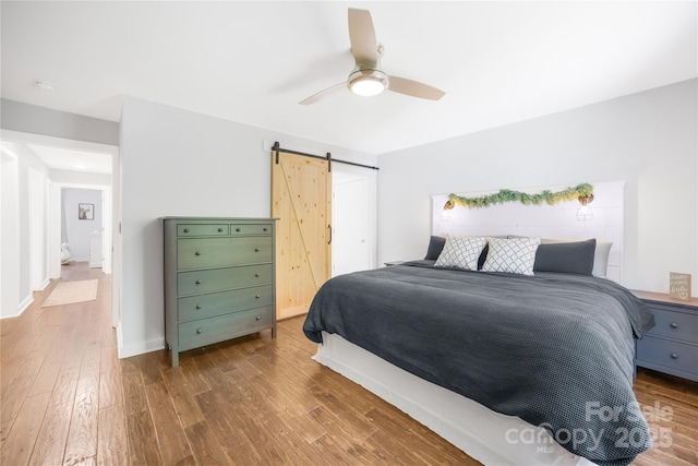 5615 American Way, Denver, NC 28037 - bedroom featuring a barn door, ceiling fan, and wood finished floors