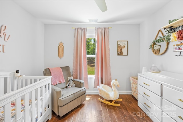 5615 American Way, Denver, NC 28037 - bedroom featuring dark wood-style flooring, a nursery area, ceiling fan, baseboards, and visible vents