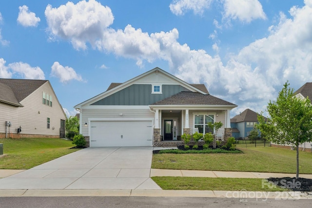 craftsman house featuring board and batten siding, driveway, a front yard, and a garage