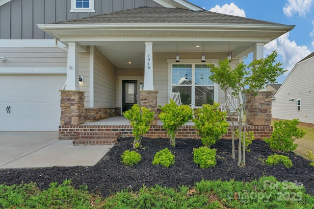 doorway to property with a garage, a shingled roof, board and batten siding, and covered porch