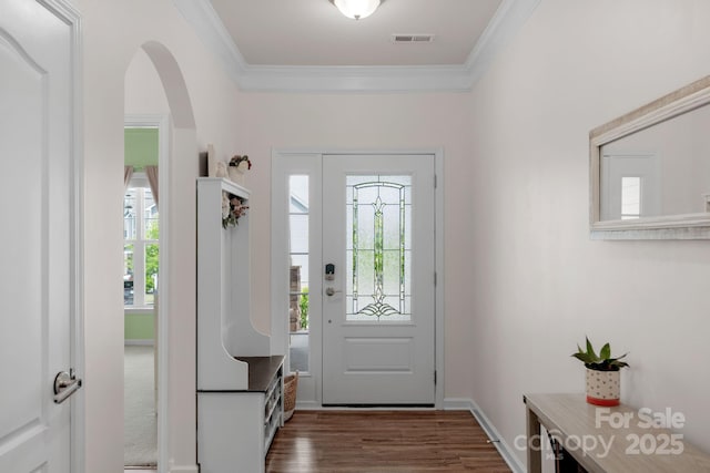 entryway with crown molding, arched walkways, dark wood finished floors, and visible vents