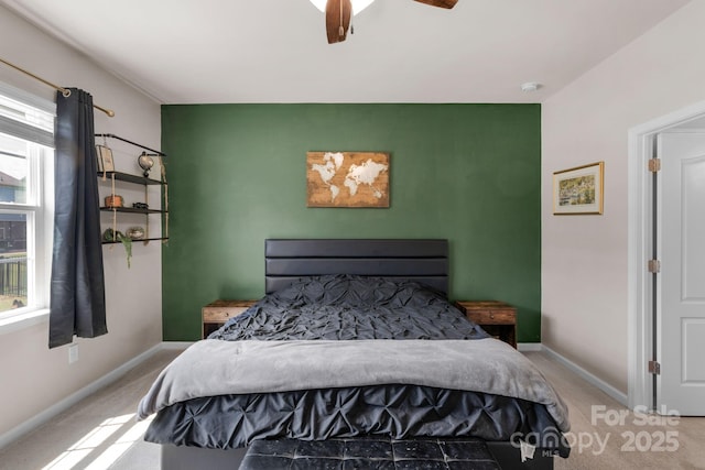 bedroom featuring baseboards, an accent wall, and carpet flooring