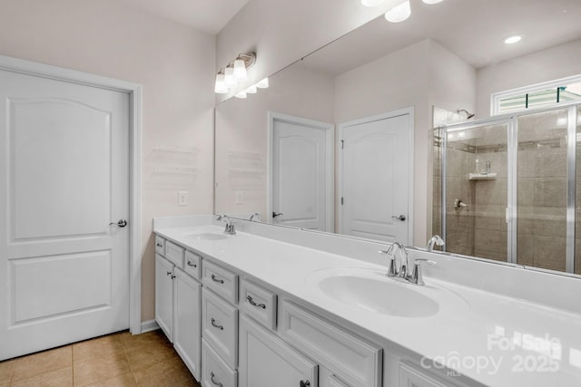 bathroom with a sink, tile patterned floors, a stall shower, and double vanity