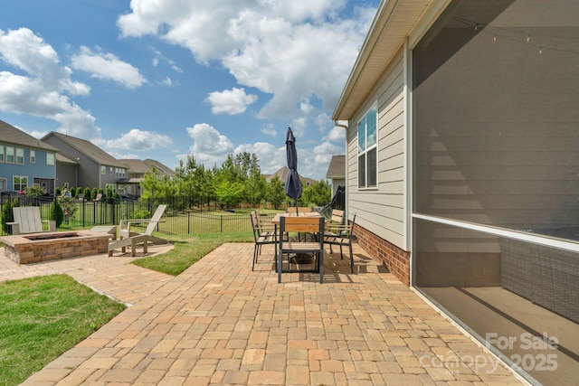 view of patio / terrace featuring fence, outdoor dining area, an outdoor fire pit, and a residential view