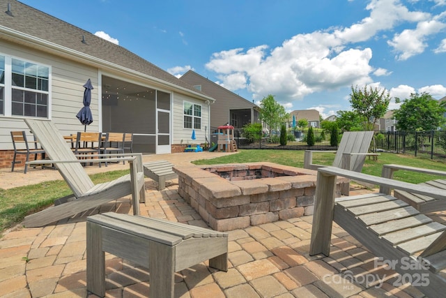 view of patio / terrace featuring a sunroom, a fire pit, and fence