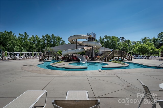 pool with a patio and a water slide