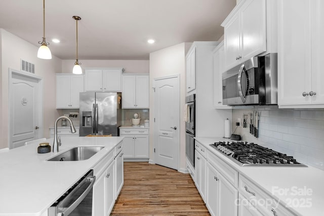 4040 Deep River Way, Waxhaw, NC 28173 - kitchen with a sink, stainless steel appliances, light countertops, white cabinetry, and backsplash