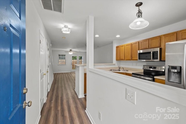 13660 Meade Glen Ct, Charlotte, NC 28273 - kitchen featuring stainless steel appliances, brown cabinetry, baseboards, light countertops, and a sink