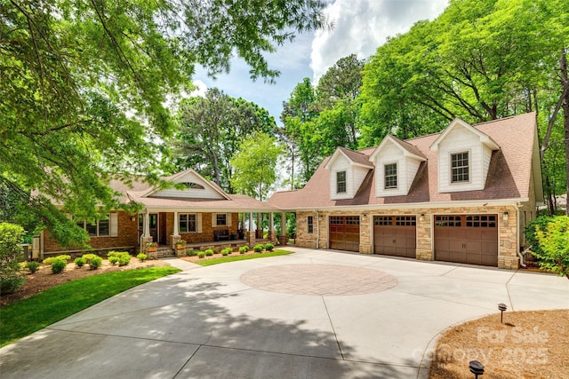 16317 Terry Ln, Huntersville, NC 28078 - cape cod-style house with concrete driveway, stone siding, an attached garage, and a porch