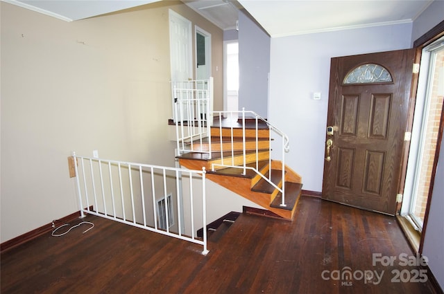 entrance foyer featuring ornamental molding, wood finished floors, and a wealth of natural light