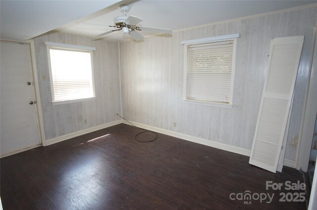 spare room featuring baseboards, a ceiling fan, and wood finished floors