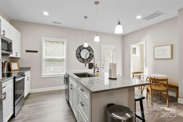 106 Dalton St, Black Mountain, NC 28711 - kitchen featuring appliances with stainless steel finishes, a breakfast bar area, baseboards, light wood-style floors, and recessed lighting